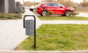 Papelera minimalista de acero gris con tapa protectora para espacios públicos